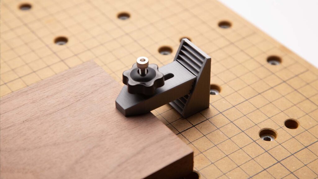 The 3D printed fixture on a CNC platform is to secure workpieces, ensuring stability and accuracy.