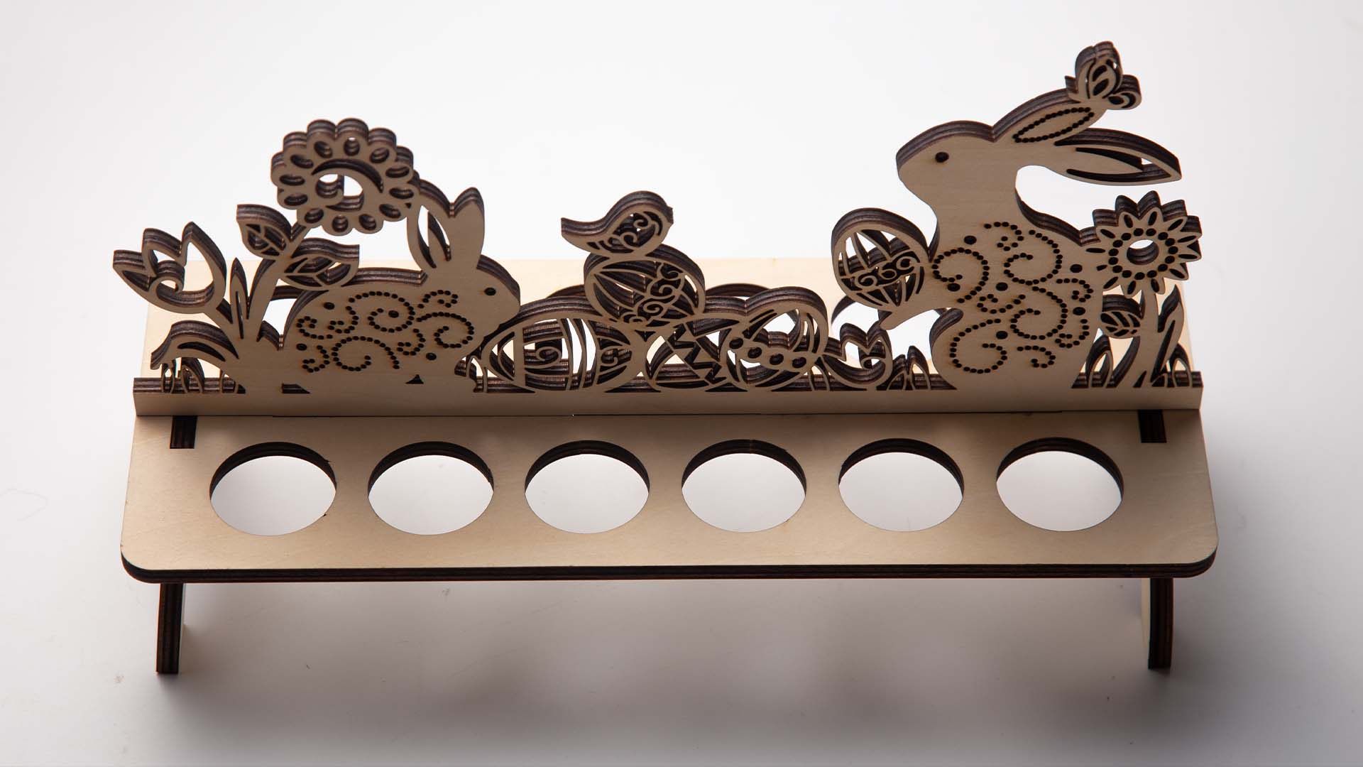 Detailed view of a wooden Easter egg stand showing the delicate laser cut pattern.