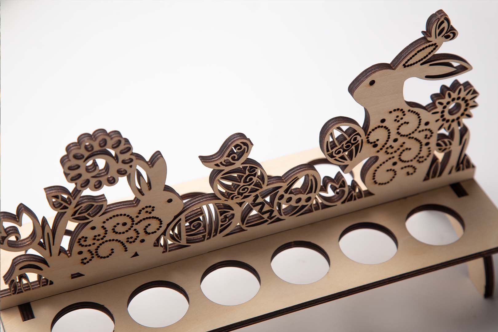 Close-up view of a laser cut wooden Easter egg stand with intricate patterns.